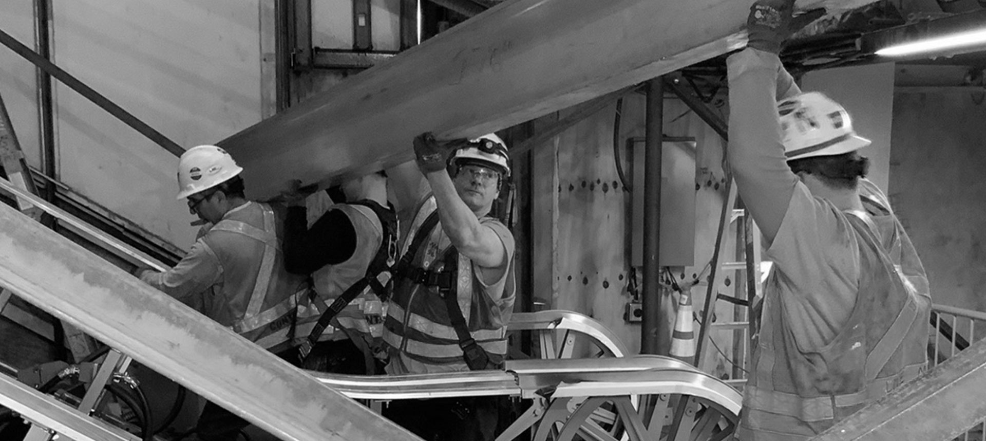 construction workers holding a beam